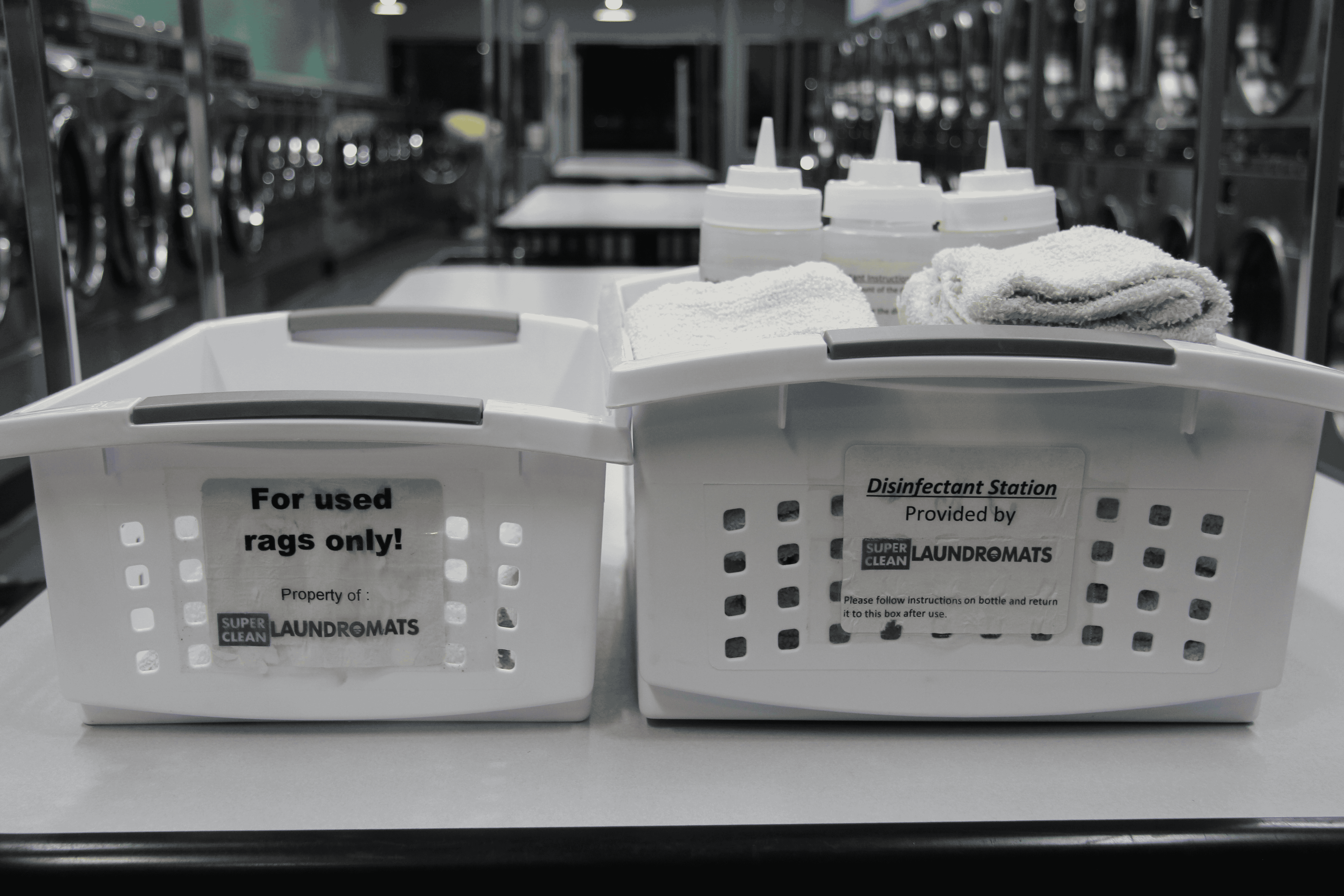 Laundry bins labeled for rags and disinfectants in facility